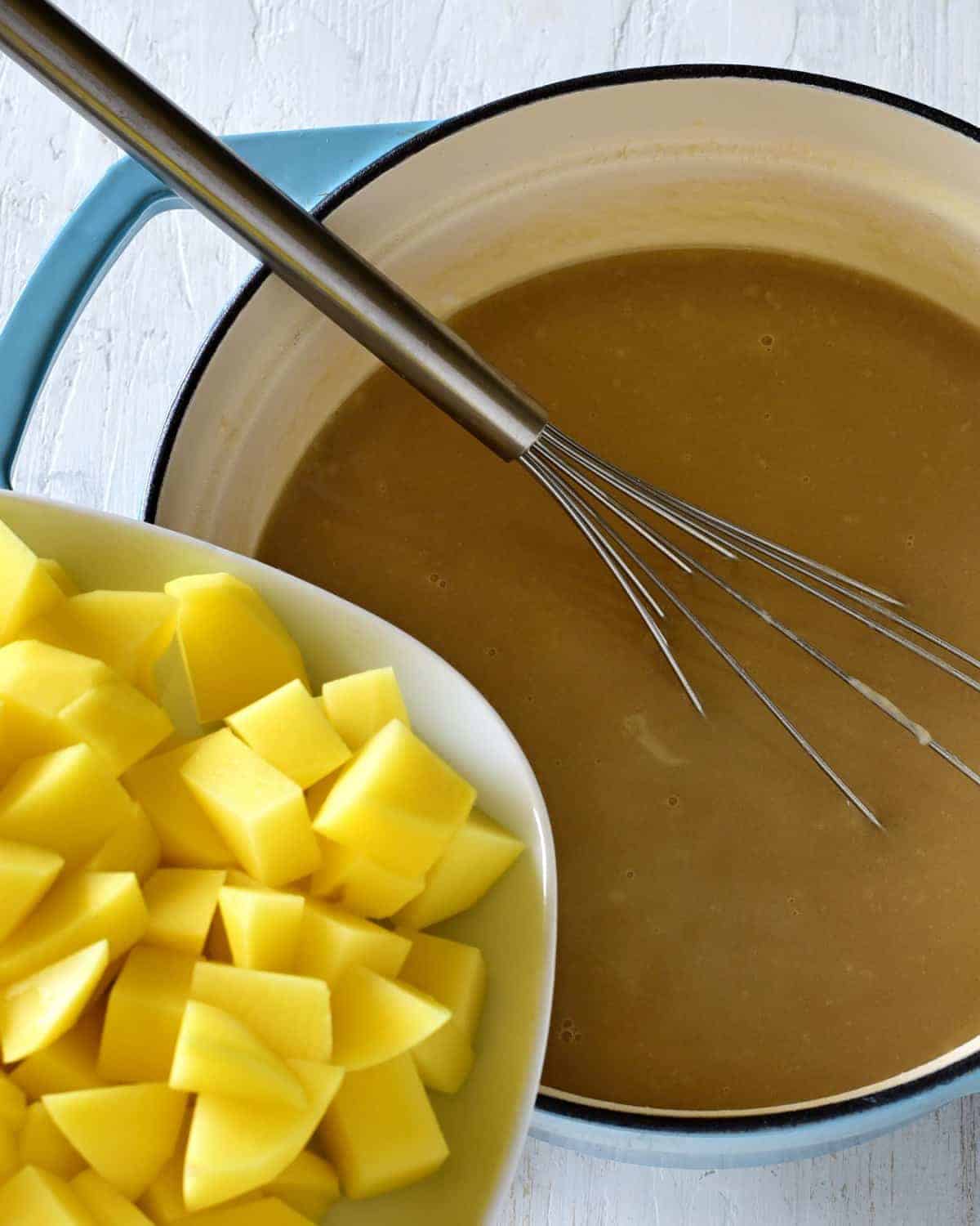 adding cubed potatoes to kulajda soup