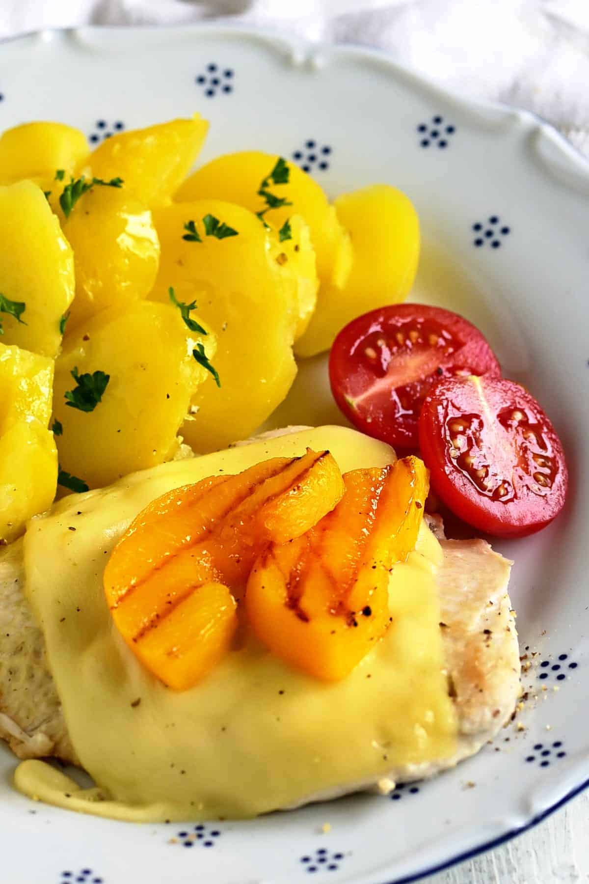 czech kuřecí plátek s broskví, served with boiled potatoes and cherry tomatoes