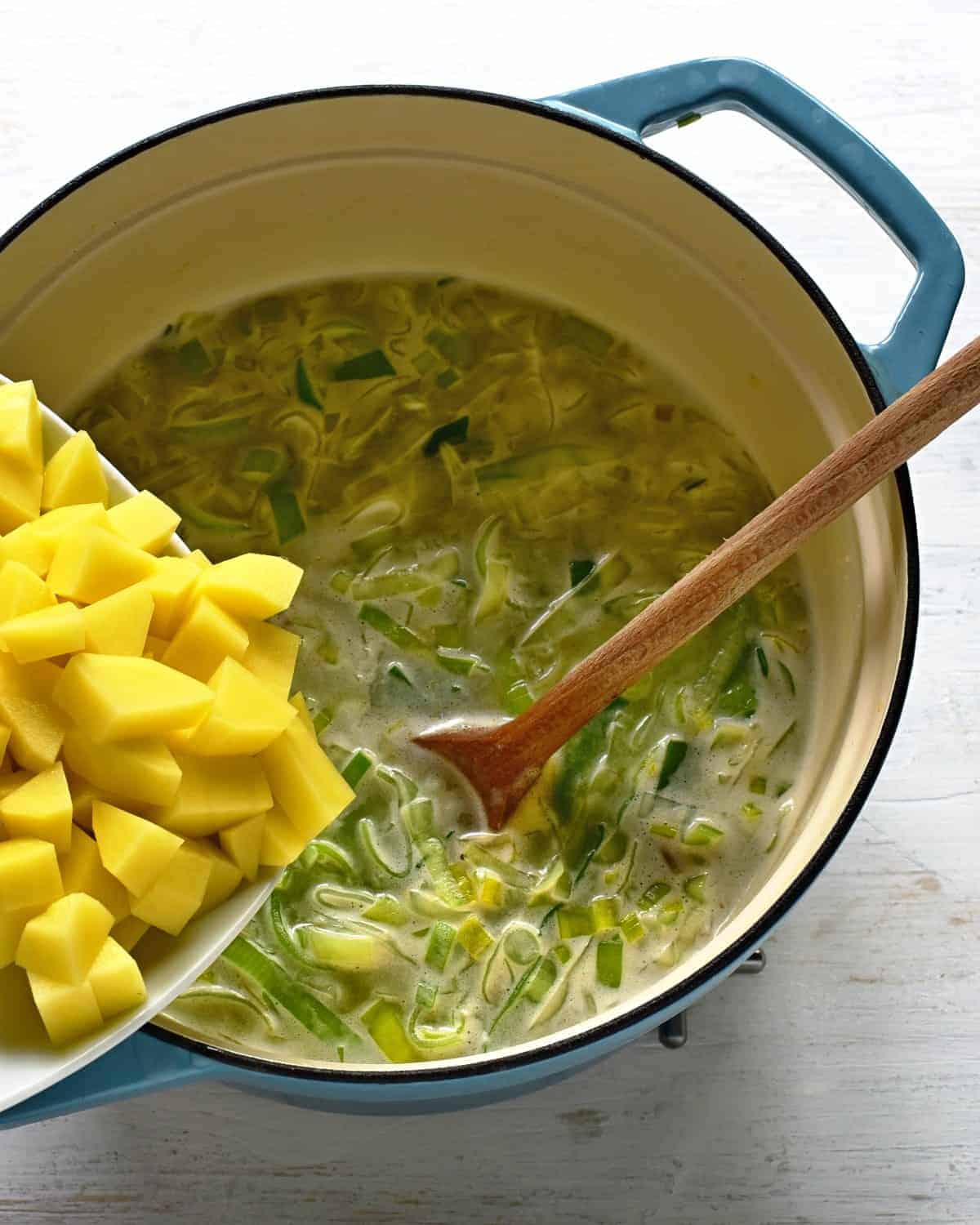 adding potatoes to a leek soup porkova polevka