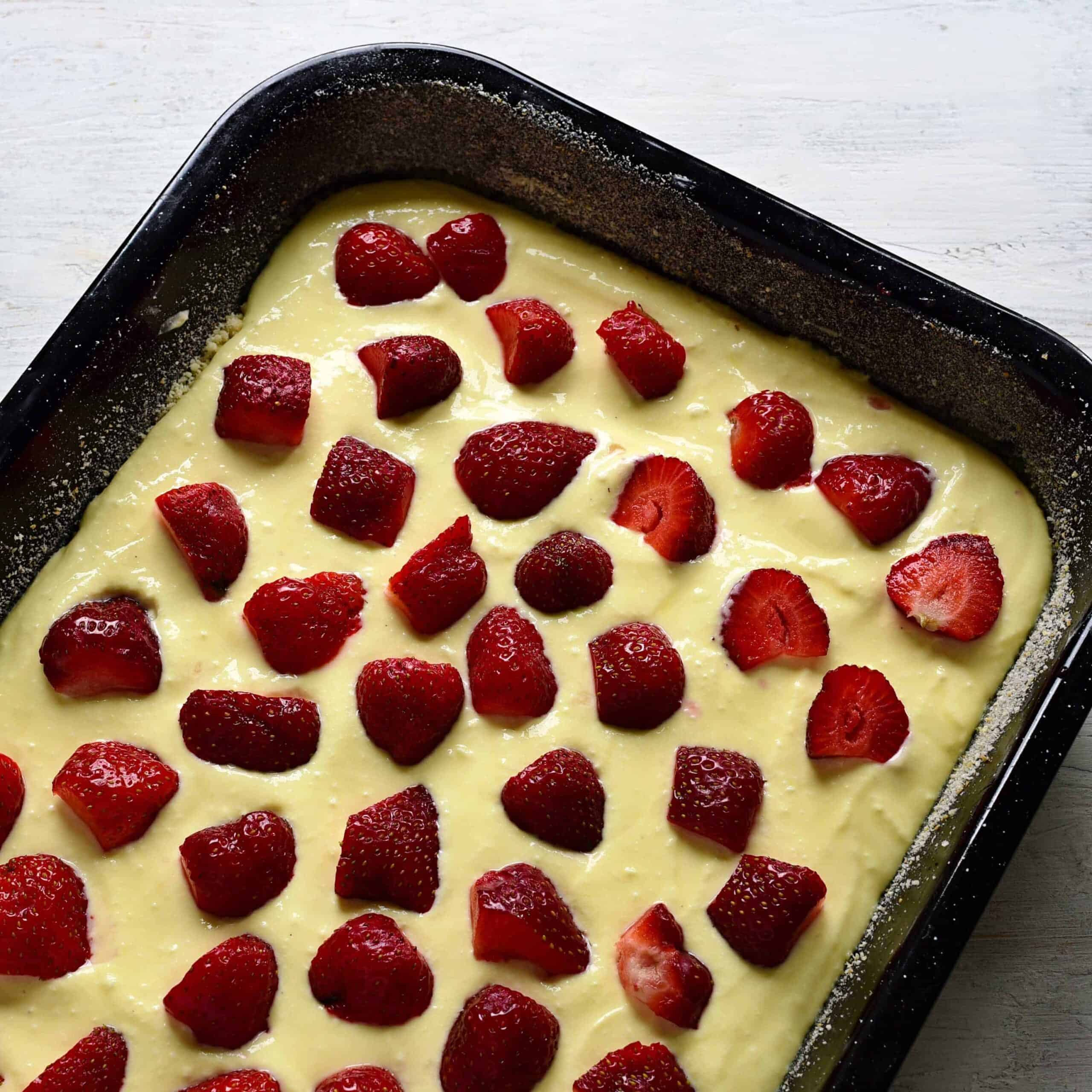 putting strawberries over cream cheese filling