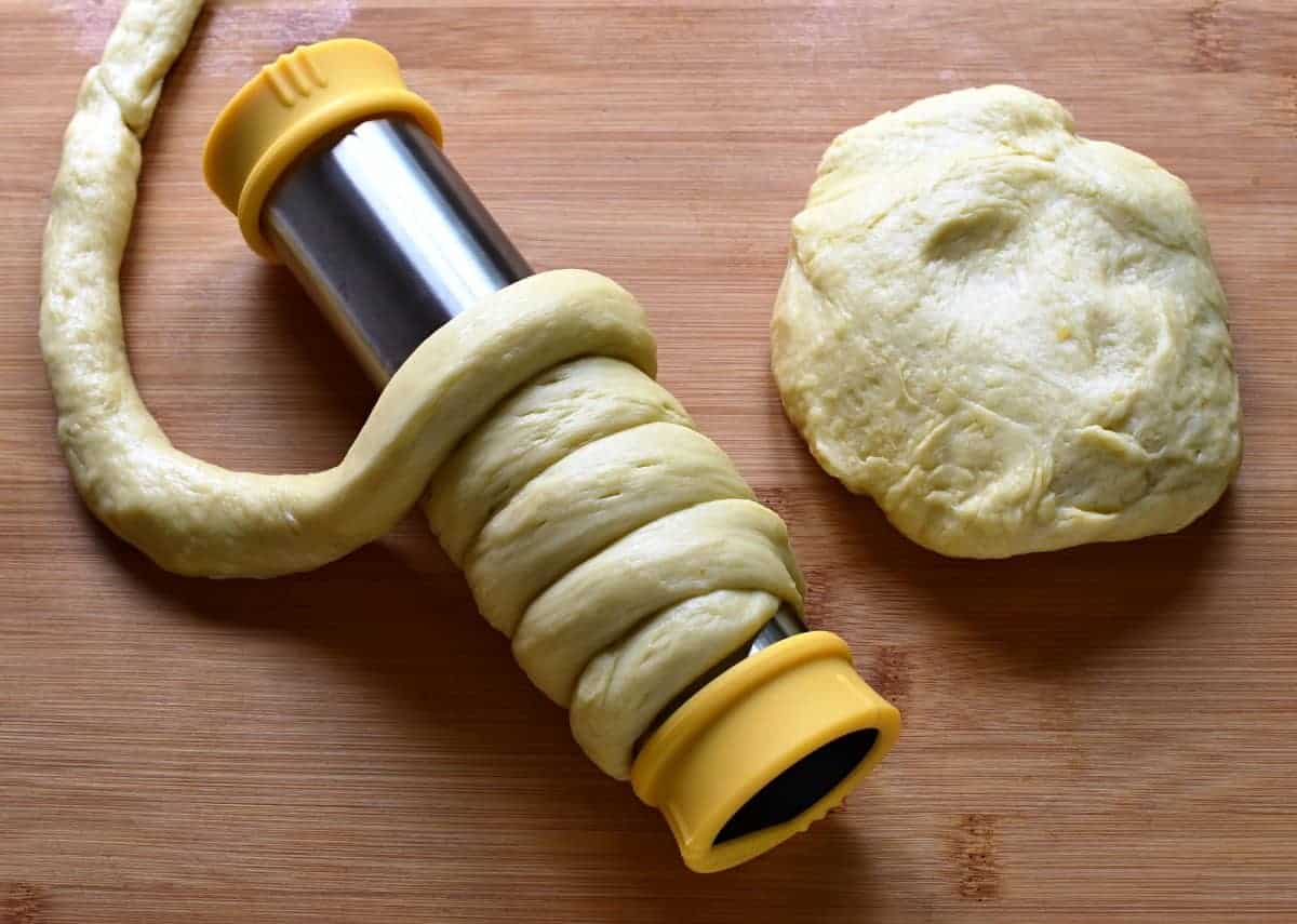 Winding dough strips around a form for trdelnik.