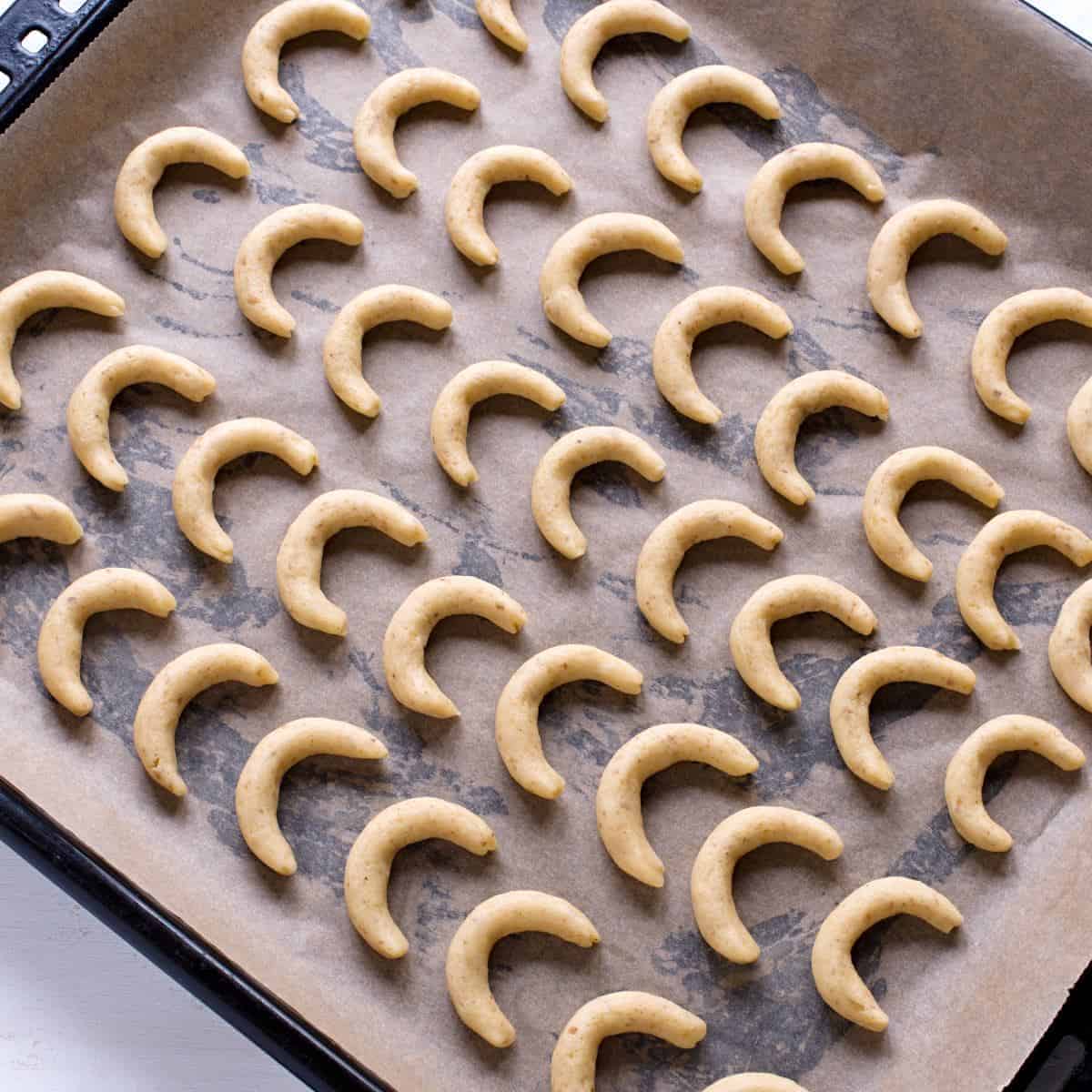Vanilla crescent cookies on a baking tray.