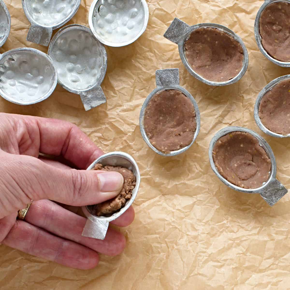 Pressing the dough into cookie molds.