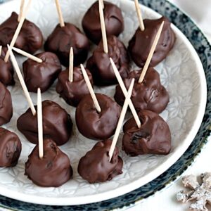 Almond stuffed prunes coated in chocolate, with toothsticks