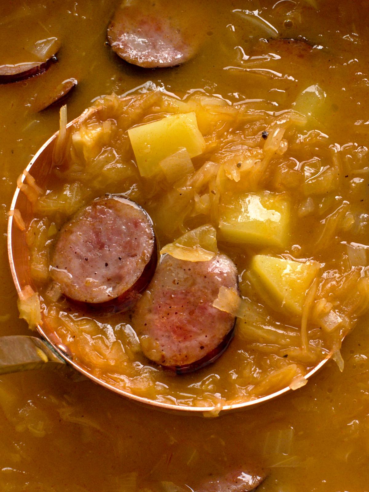 Cooked sauerkraut soup with fried sausage.