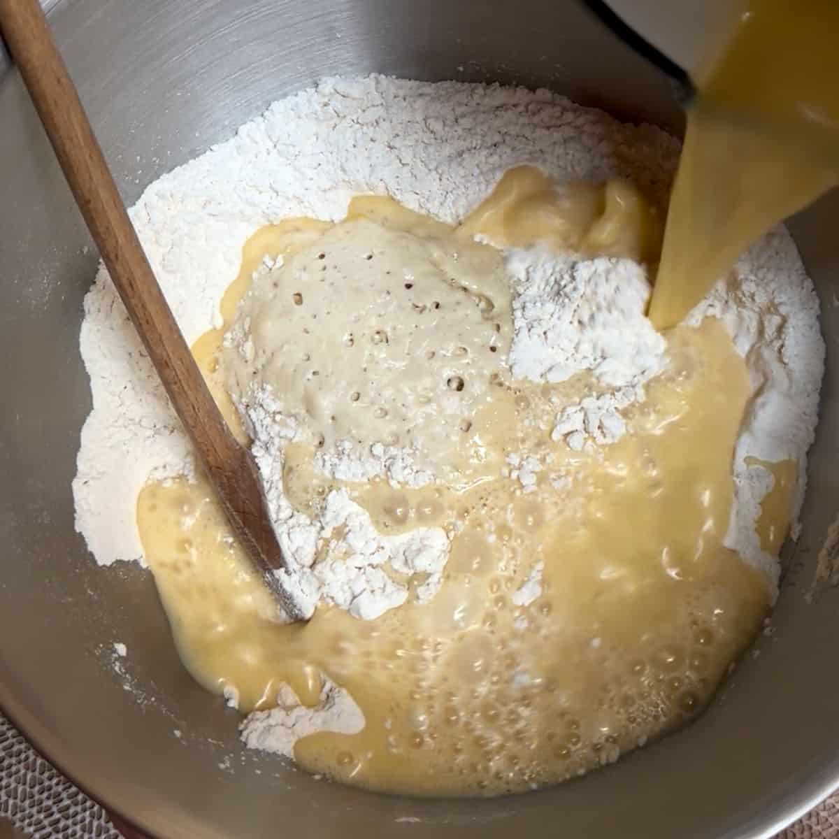Making yeast dough in a bowl. Adding liquid ingredients.