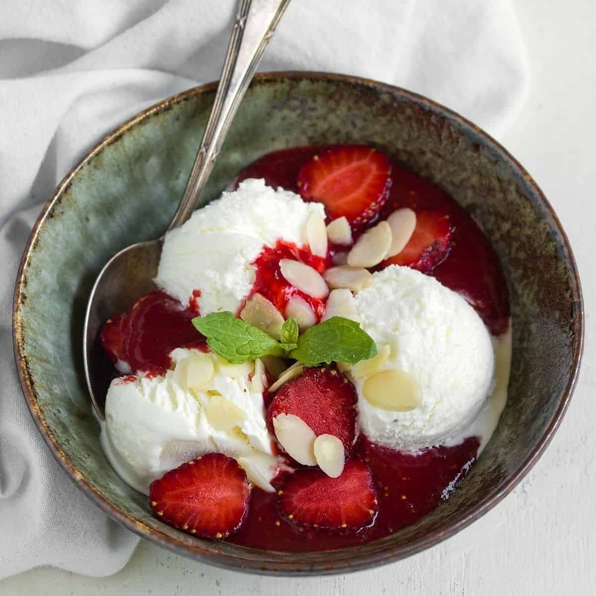 Cold strawberry sauce in a bowl with ice cream.