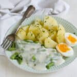 Green beans in white creamy sauce, served with boiled potatoes and an egg.