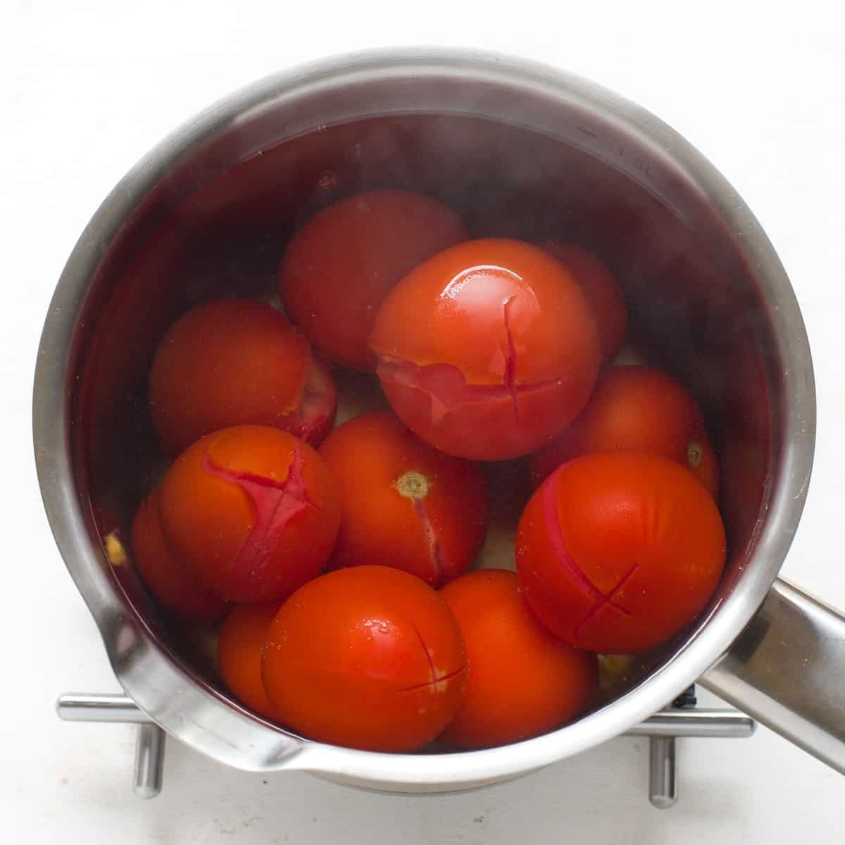 Tomatoes in a pot, scalded with hot water.