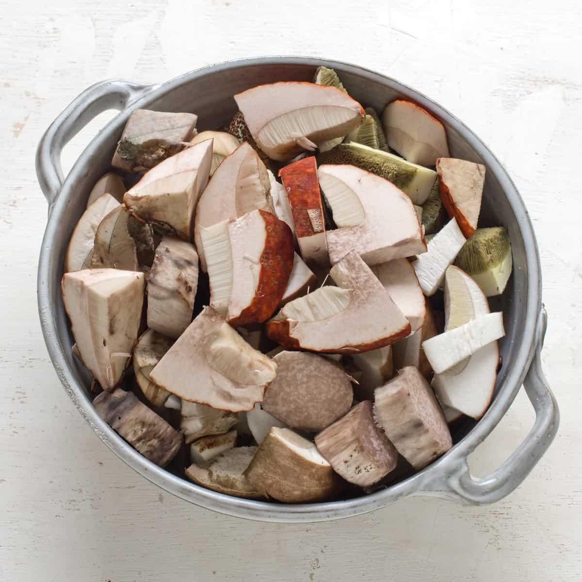 Fresh mushrooms sliced into chunks, stored in a bowl.