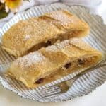 Puff pastry apple strudel slices, served on a plate.
