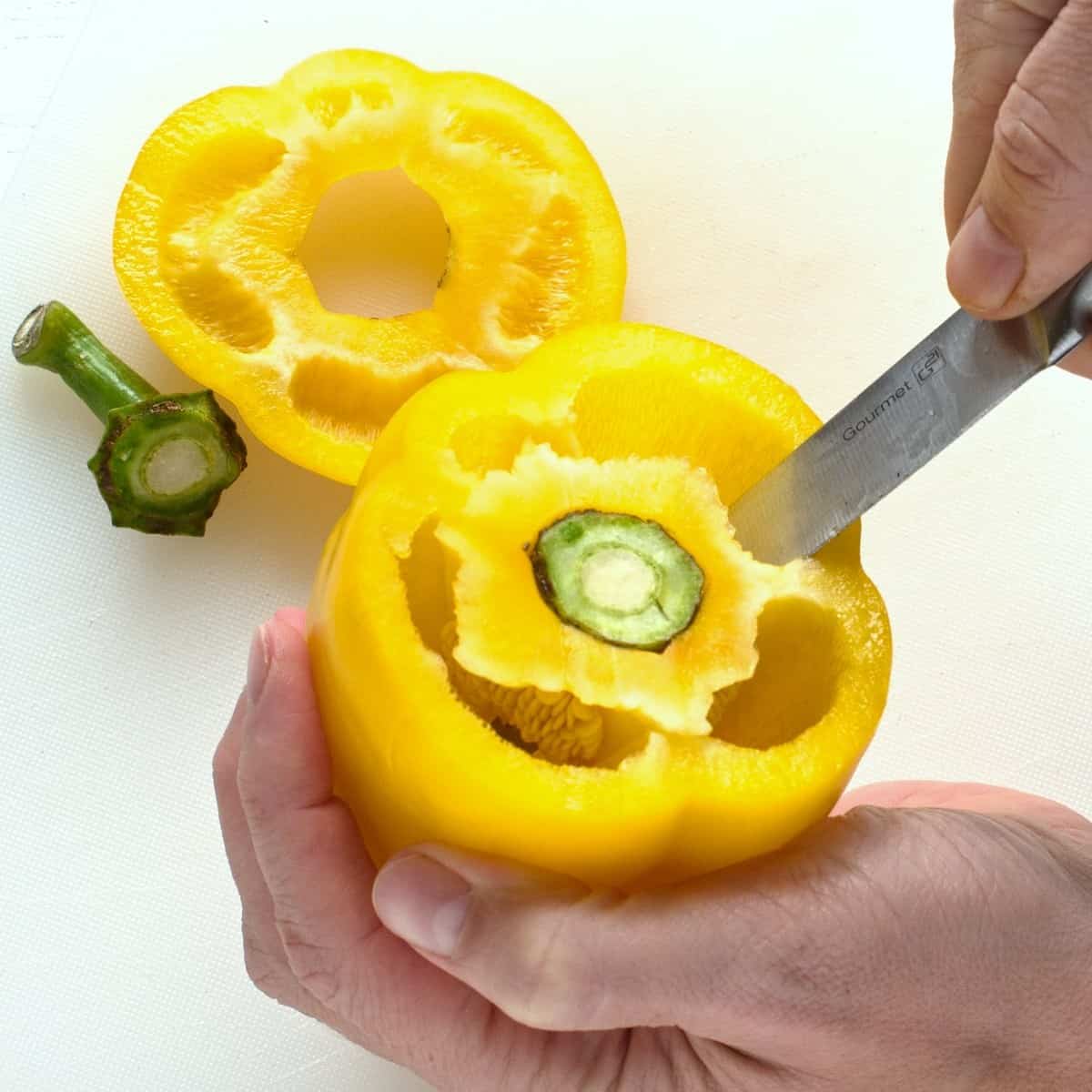 Cutting out a core of a yellow bell pepper.