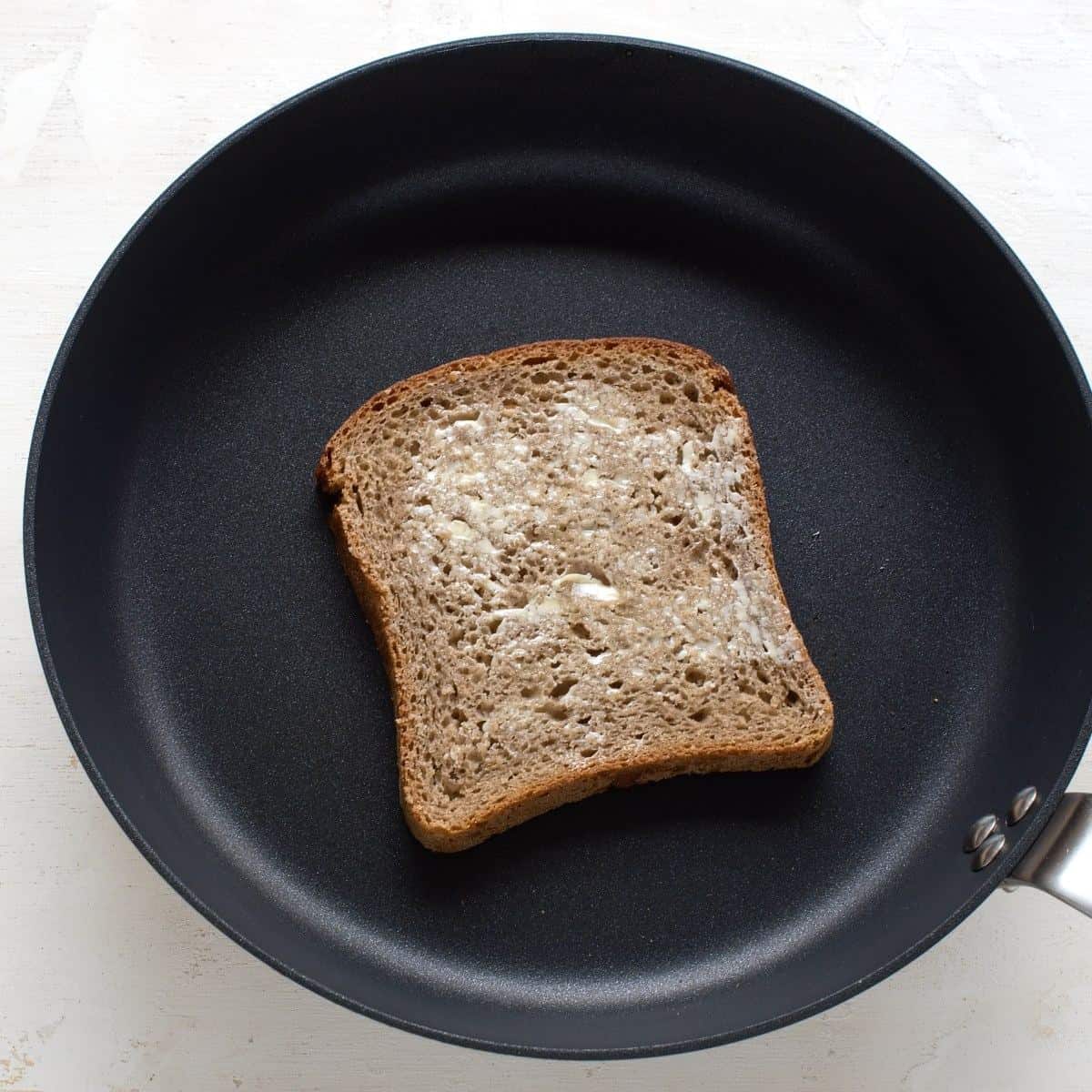 Frying a slice of bread in a skillet.