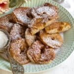 Fried apple rings served on a green plate.