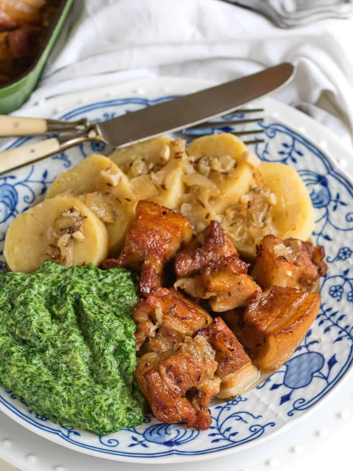 Pork belly bites served with creamed spinach and potato dumplings.