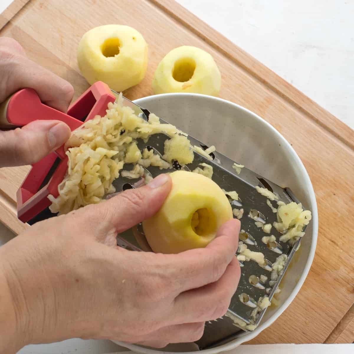 Shredding apples on a hand grater box.