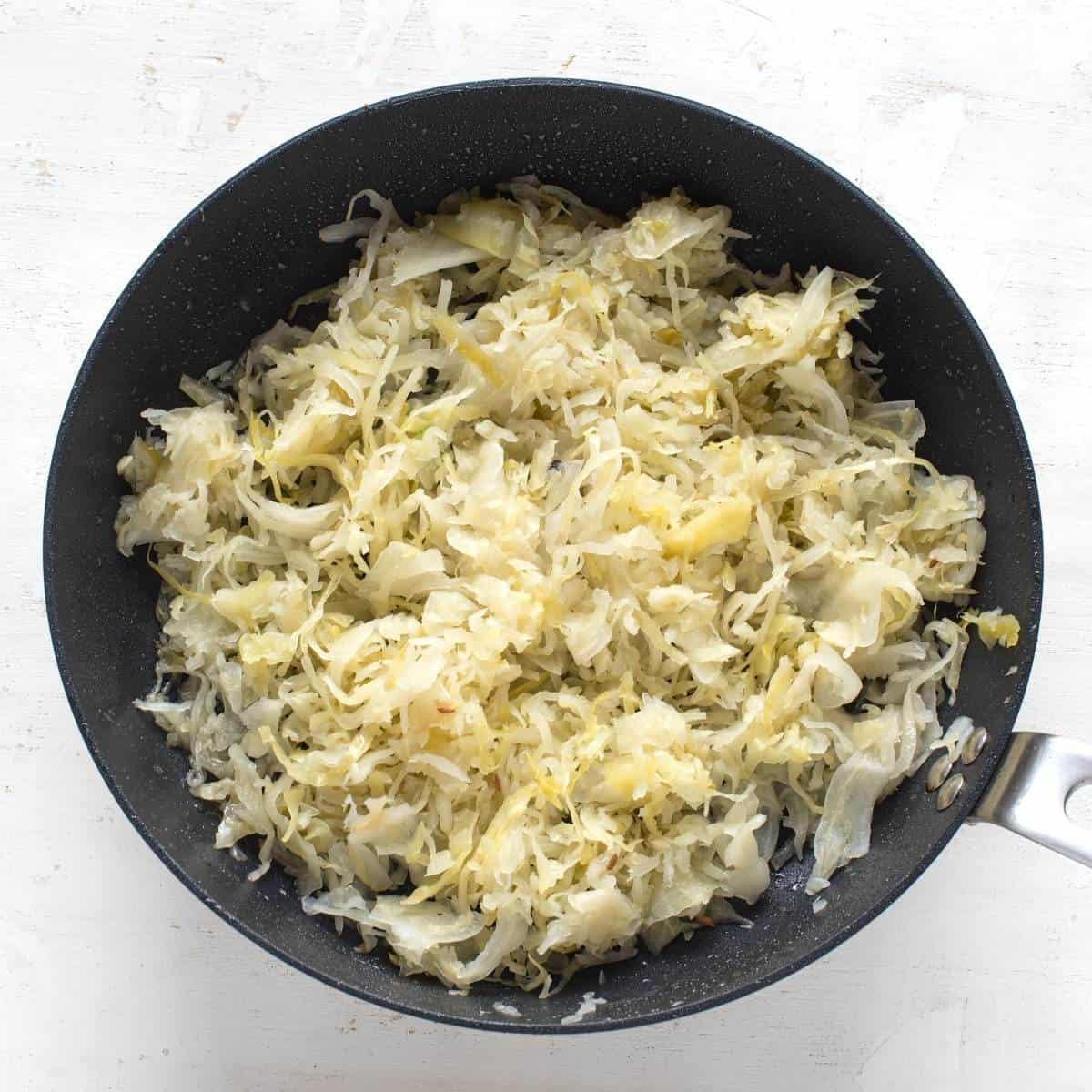 Sauerkraut is frying in a pan.
