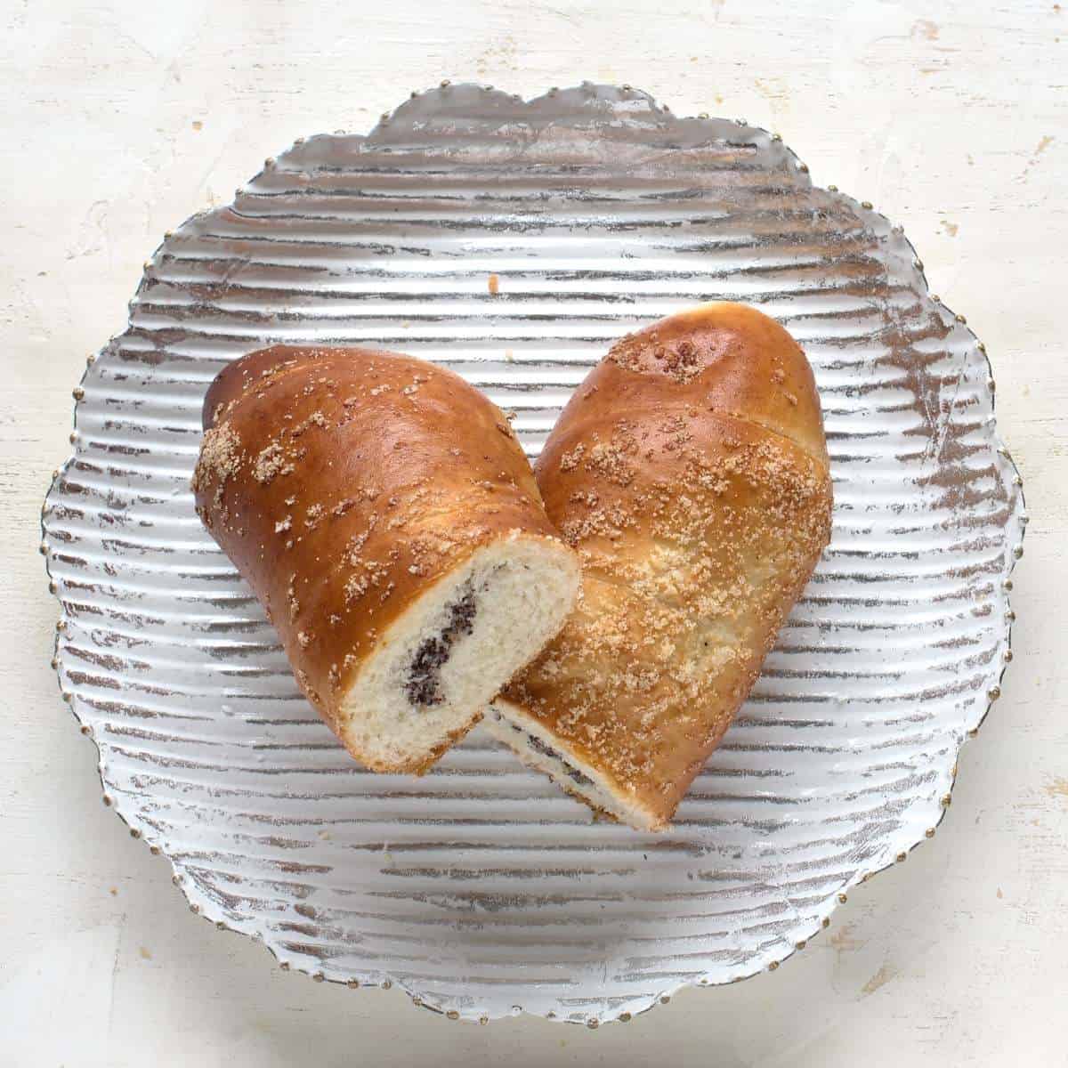Jestedka pastry roll filled with poppy seed, served on a plate.