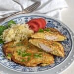 Meat stuffed potato pancakes served on plate, with sauerkraut as a side dish.