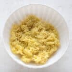 Finely shredded potatoes in bowl.