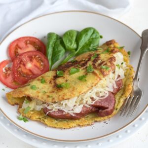 Stuffed potato pancake with smoked meat and sauerkraut, served on a plate with a fork.