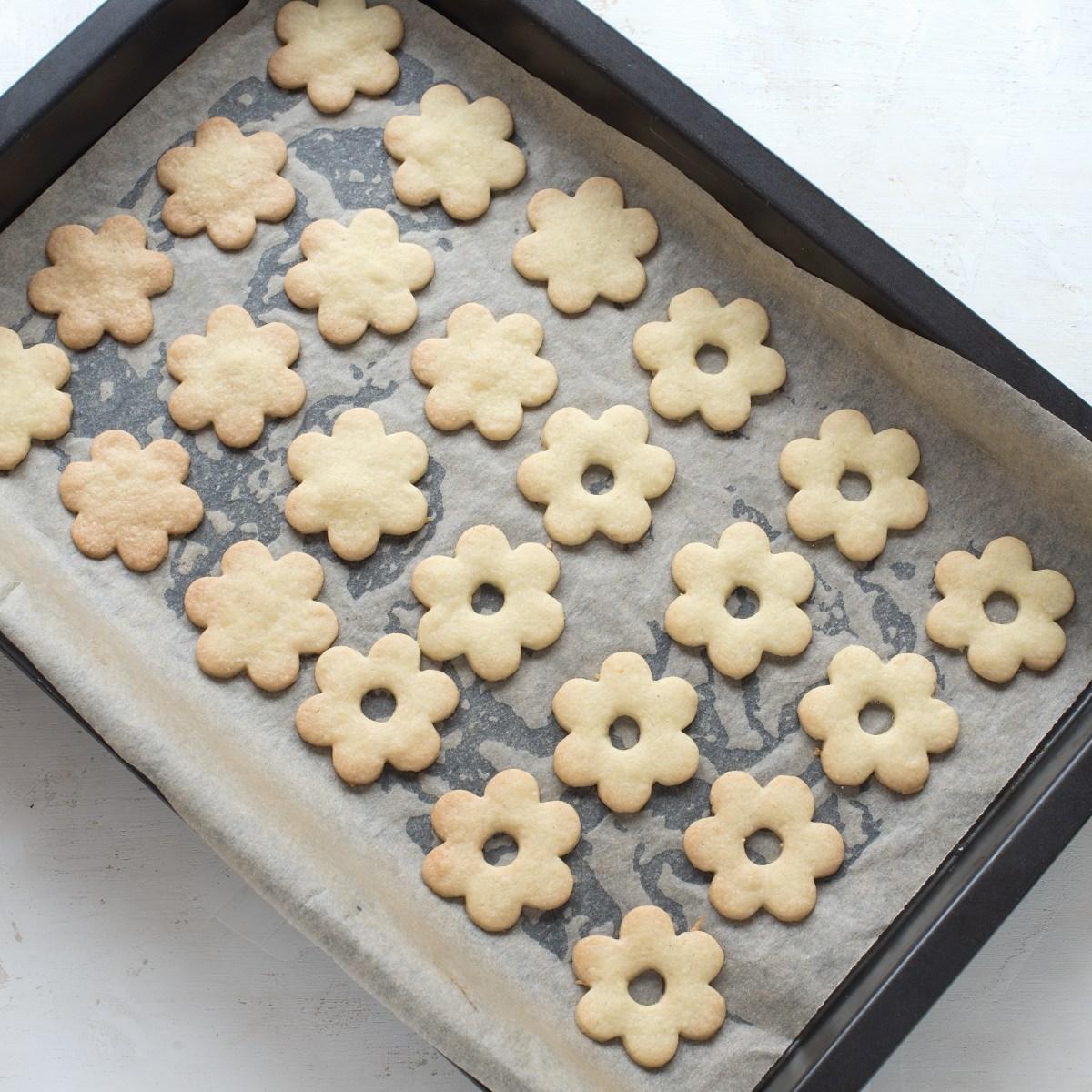 Baked Linzer cookies on a baking sheet pan.