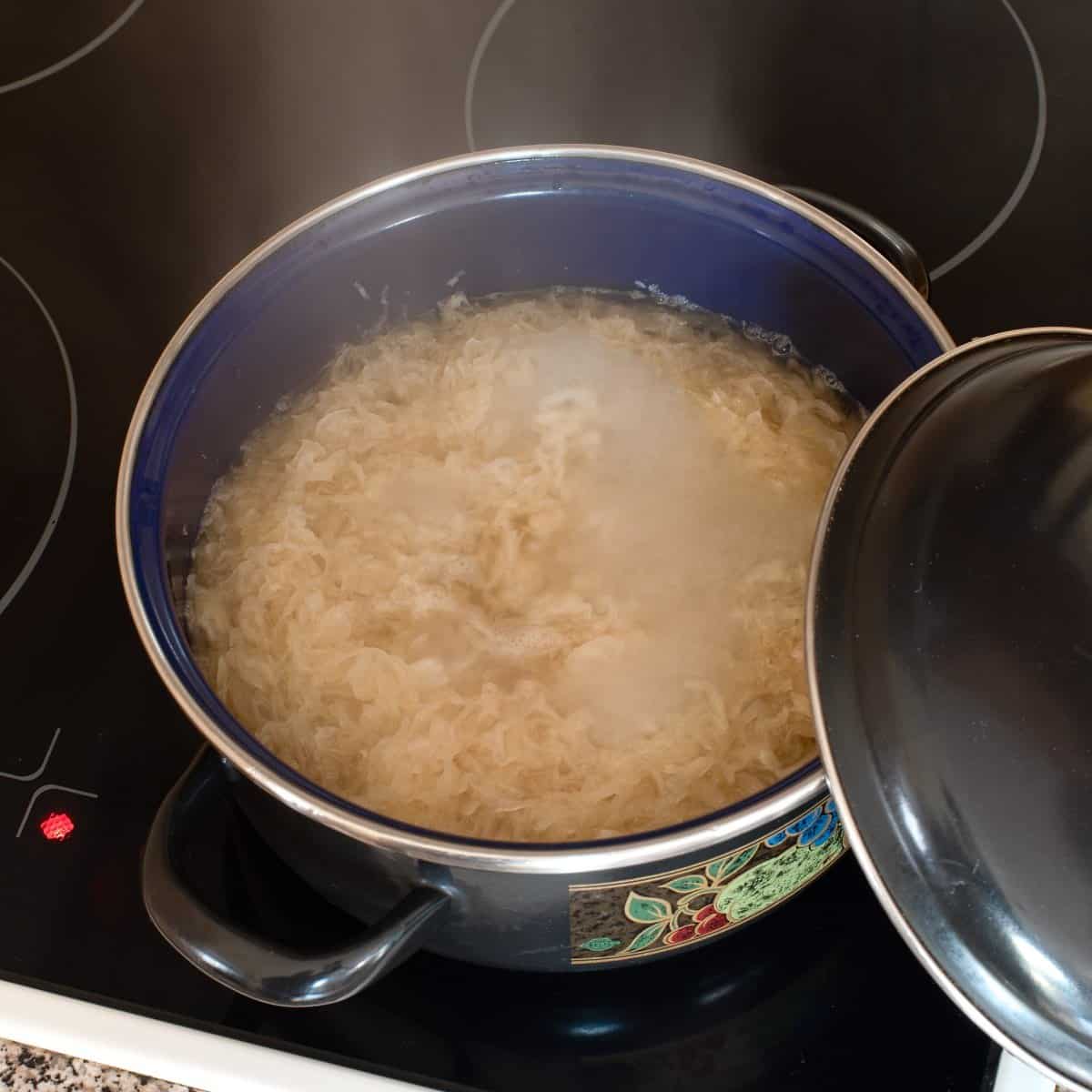 Sauerkraut cooked in a pot on a stove.