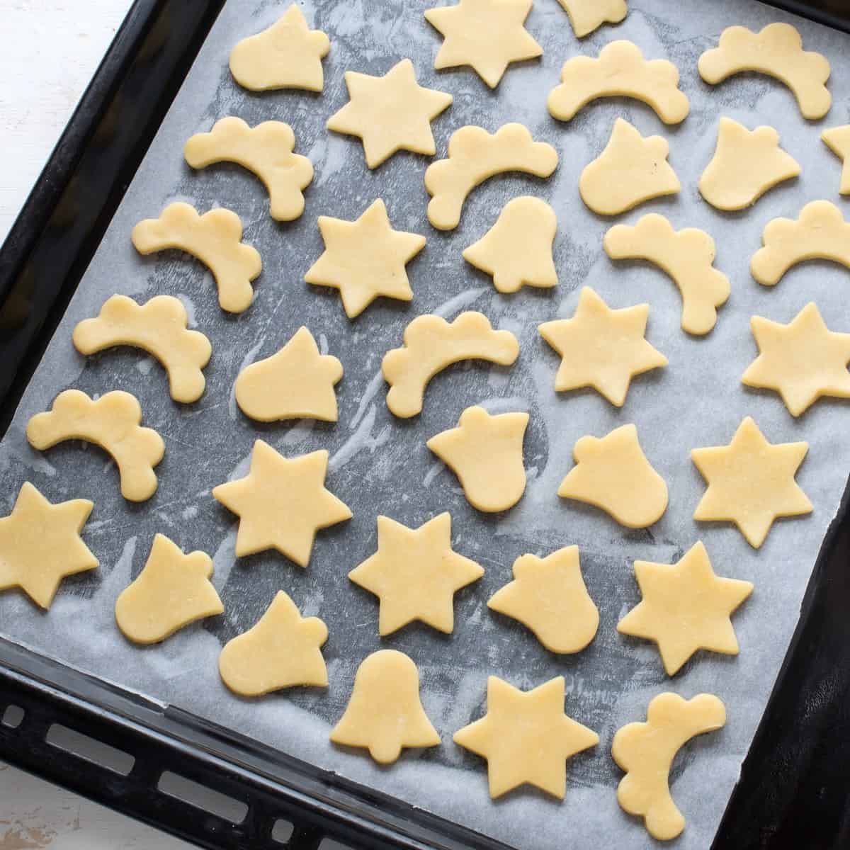 Cookie cutouts arranged on a baking sheet.