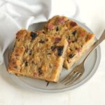 Hubnik, Czech mushroom bread pudding slices, served on a plate with a fork.