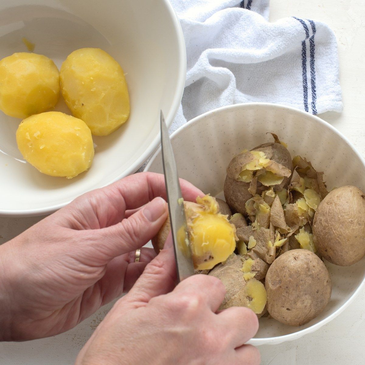 Peeling skin of boiled potatoes.
