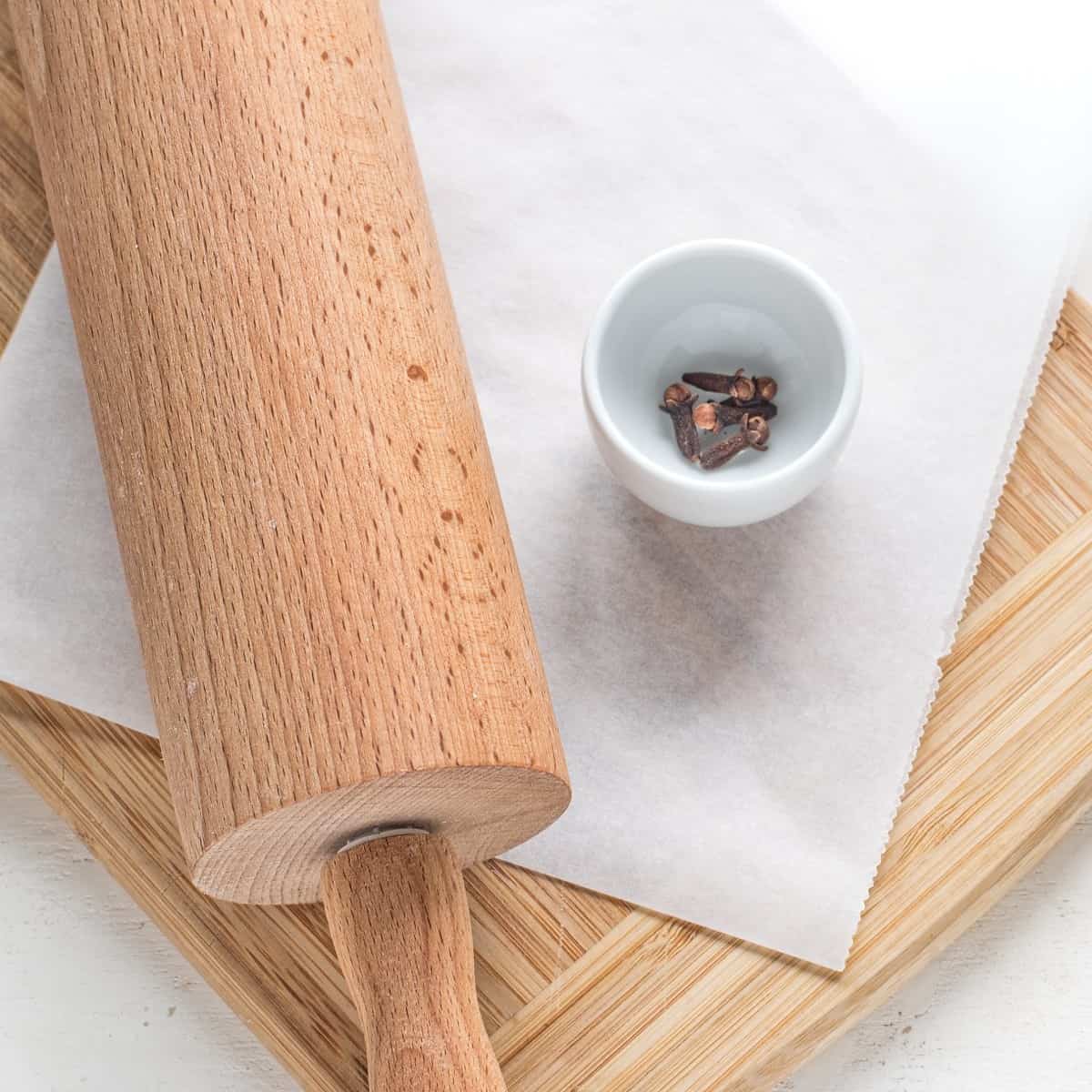Cloves and rolling pin for crushing spices.