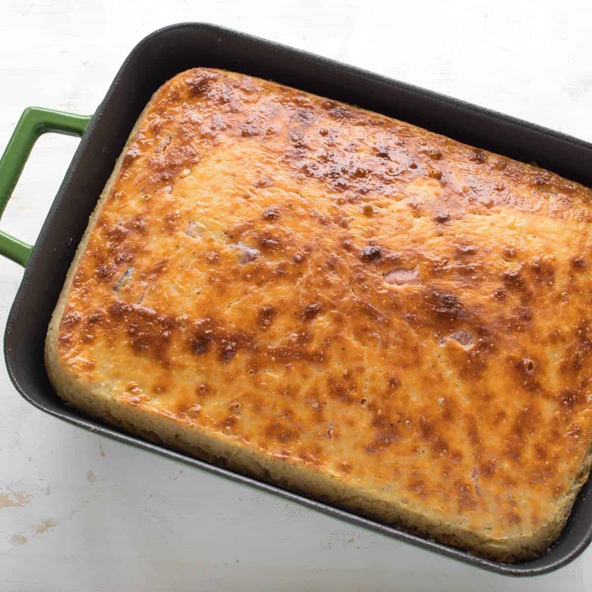 Savory potato cake baked in a rectangular sheet pan.