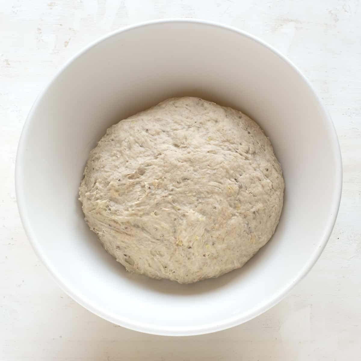 Bread dough in a white bowl.