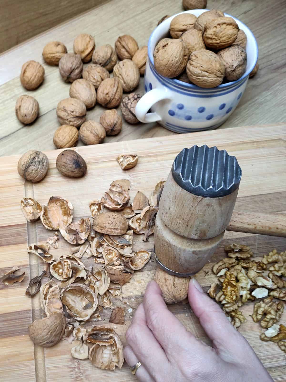 Cracking the walnuts with a wooden mallet.