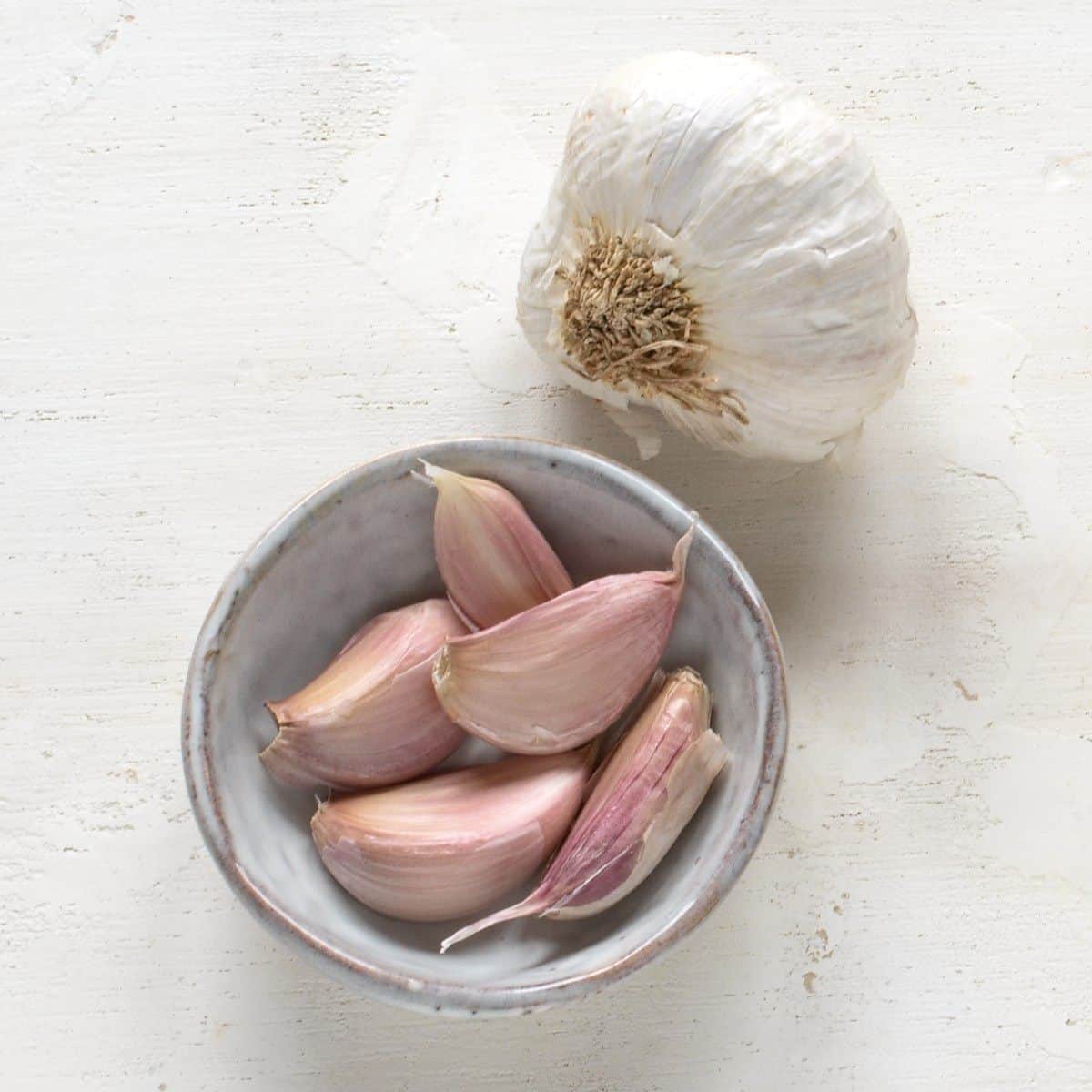 Garlic cloves in a small grey bowl.