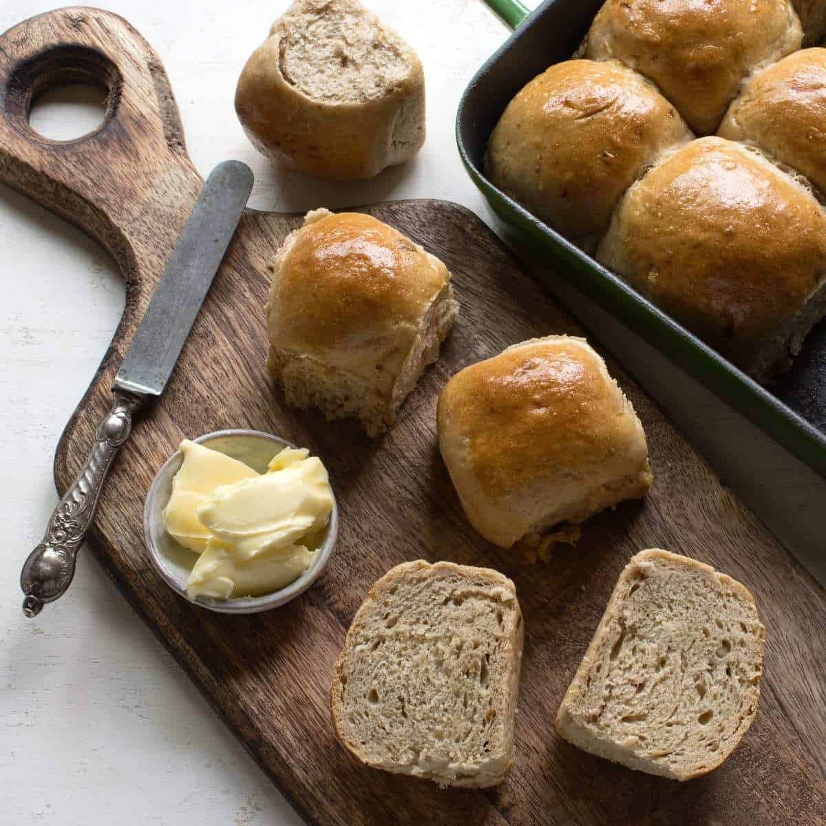 Baked bread rolls on a brown wooden board.