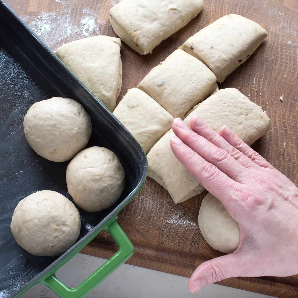 Rolling a piece of a yeast dough into a ball, making bread rolls.