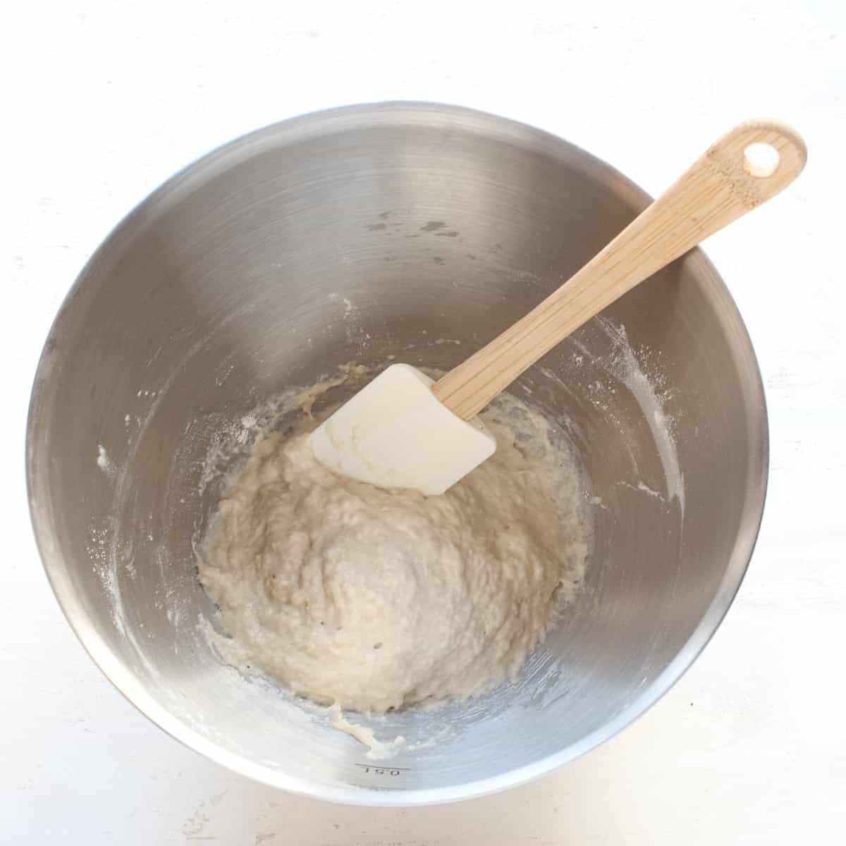 Making yeast starter in a stainless bowl, with spatula.