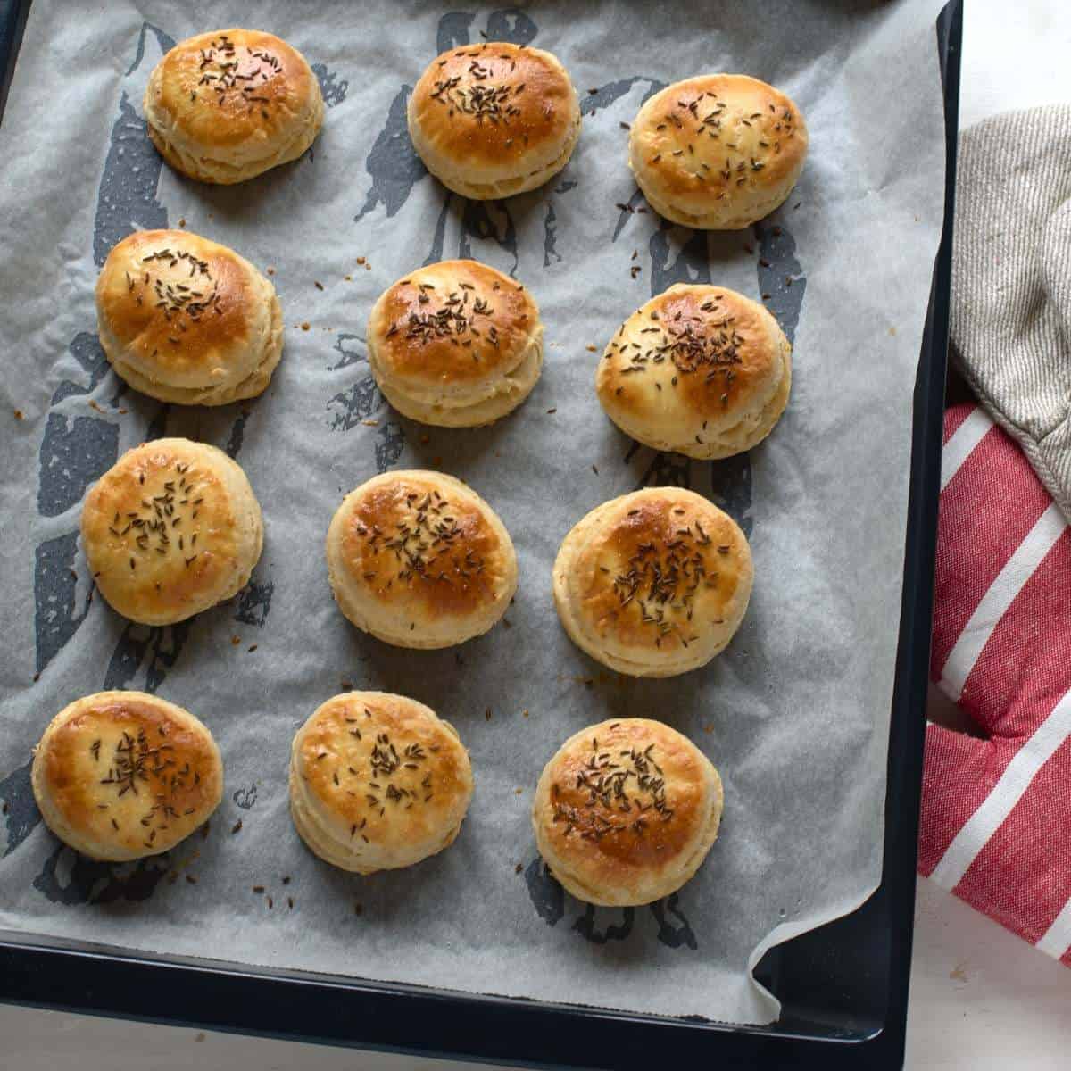 Baked pork cracklings biscuits on a baking sheet.