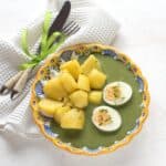 Czech green spinach sauce served with boiled potatoes and a halved hard-boiled egg.