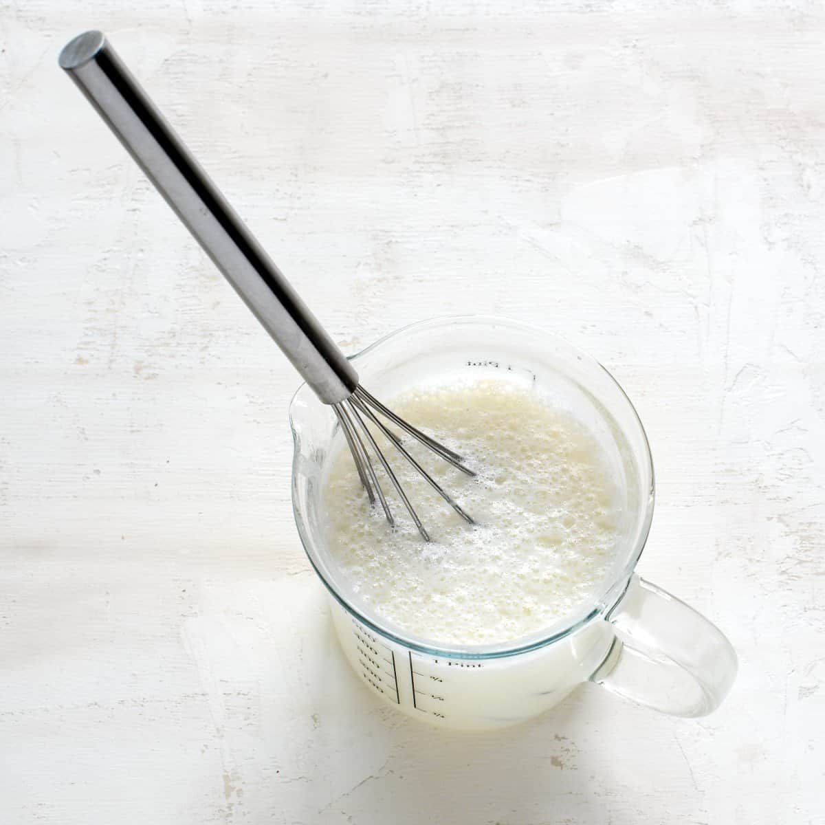 Flour whisked with milk in a glass.