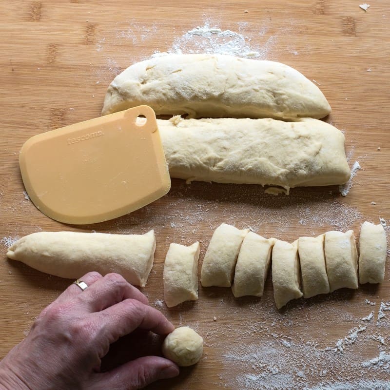 Shaping bobalki balls from cut pieces of yeast dough.