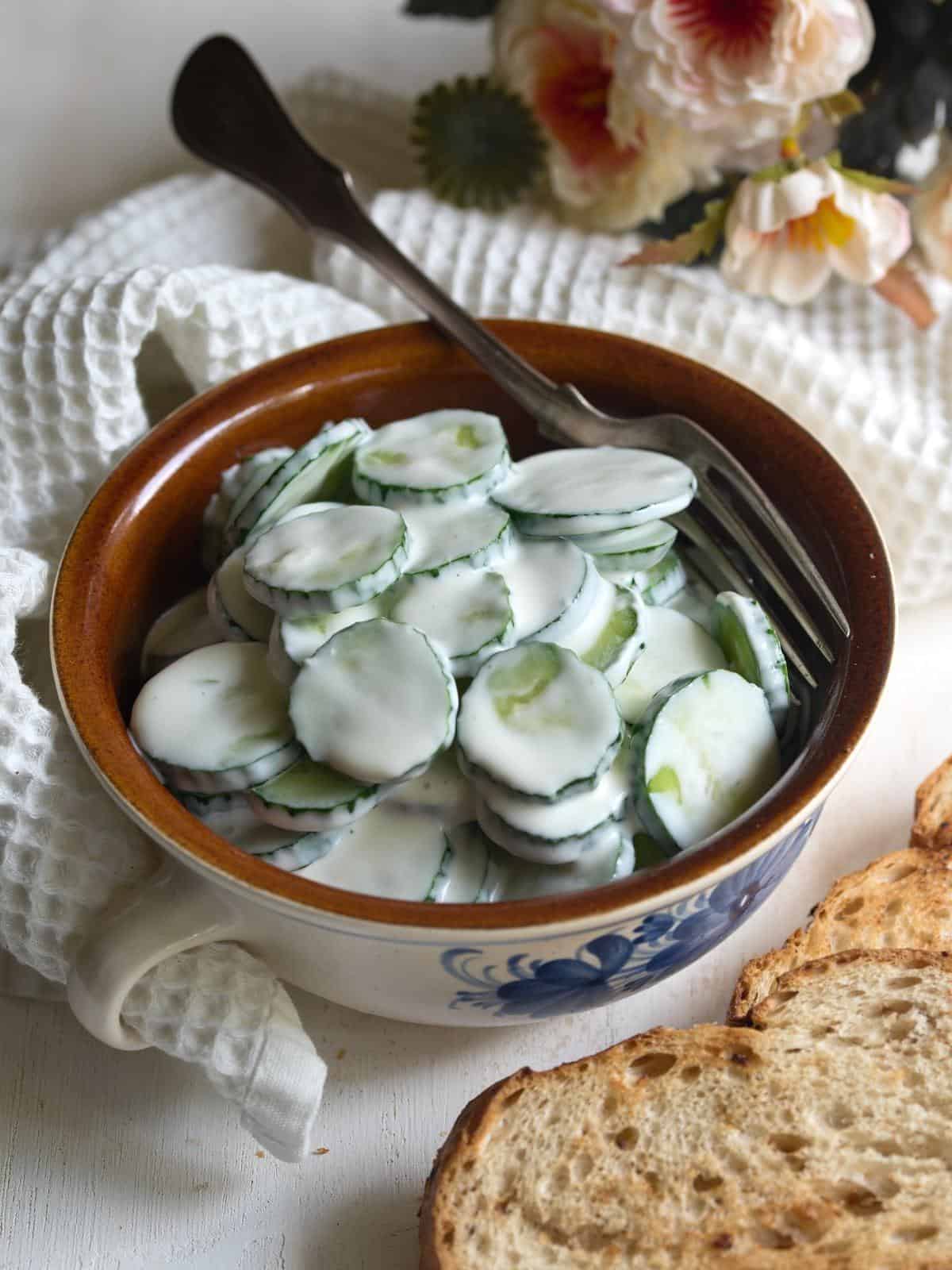 Creamy cucumber salad with garlic served in a bowl.