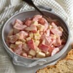 Tomato and cheese salad in a bowl served with crunchy bread.