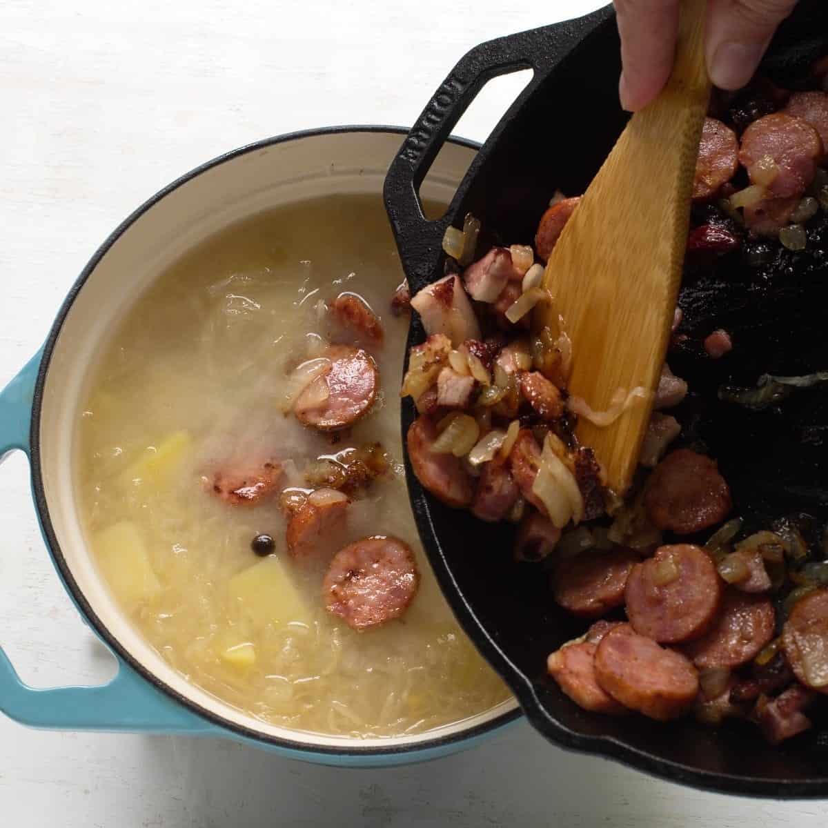 Adding fried slices of sausage and onion into Czech Kyselica soup.