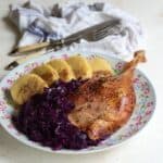 Roast goose served with red cabbage and potato dumplings.