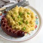 Czech potato sauerkraut mash (Lepenice) served on a plate with fried smoked sausage.
