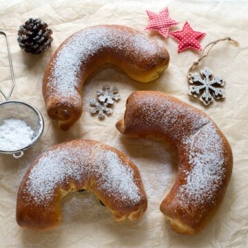 Three Czech poppy seed horse shoe rolls, called Martinske podkovy. Dusted with powdered sugar.