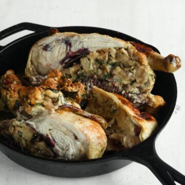 Roasted stuffed chicken, cut into portions. In a cast iron pan.
