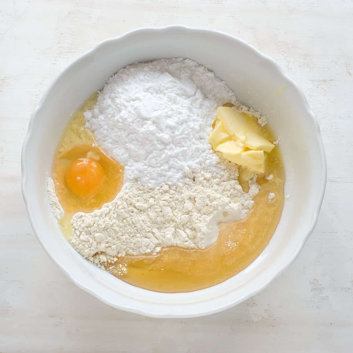 Ingredients for honey dough placed in a white bowl.